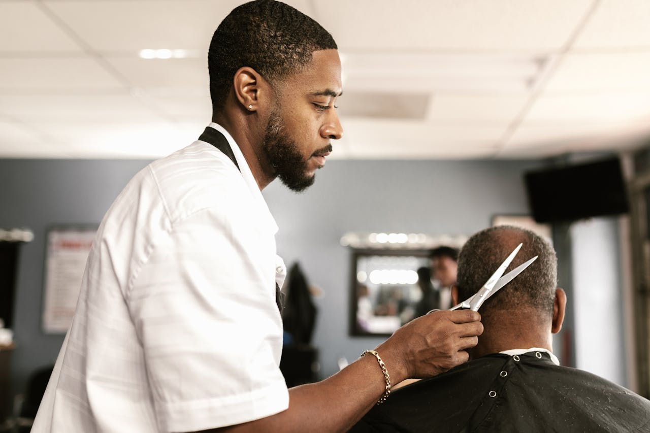 A skilled barber provides a haircut to a client in a modern barbershop setting.